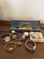 All watches arranged on table with Swissfield box in background