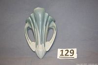 Front view of antique drip style wall pocket showing blue and cream glaze with symmetrical cutout design.