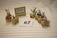 Seven ceramic bunny rabbit figurines arranged in a school scene, teacher, students, blackboard and desks