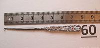 Full view of the antique sterling silver button hook placed against a ruler showing length approximately 7.5 inches and the hook end detail.