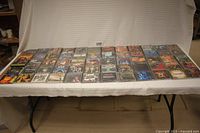 Wide view of 40 CDs laid out in 4 rows showing various album artwork from the lot of hard metal and rock music CDs.