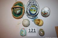 Seven decorative eggs arranged together showing variety in design, sizes and packaging.