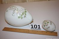 Photo showing both antique hand-blown Easter eggs side by side with ruler for scale and lot tag number 101