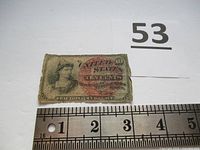 Front side of a U.S. fractional currency note (shinplaster) for 10 cents showing an allegorical image of Liberty and red overprint, with visible wear and measuring scale.