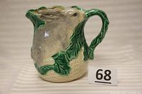 Front view of the ceramic pitcher showing the detailed hand painted rabbit and leaf designs, with the number 68 placard.