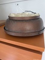 Side view of one copper ceiling lamp showing patinated exterior and mounting plate