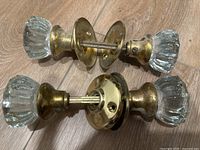 Both door knob assemblies showing glass knobs and brass hardware