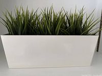 Rectangular white planter with three artificial grass plants