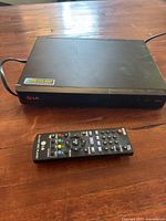 LG Blu-ray player with remote displayed on wooden surface