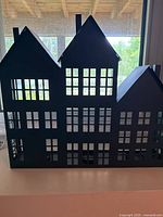 Front view of black metal house-shaped tealight holder