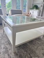 Three-quarter view showing overall design, glass top, drawer and shelf