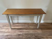 Front view of console table showing oak-stained top and white legs