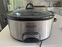 Front view showing stainless exterior, glass lid, control panel