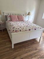 Full view of assembled white IKEA Hemnes queen bed frame with headboard, footboard and side rails