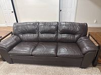 Front view of brown leather three-seat couch