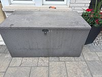 Front view of grey woven-texture metal deck box closed