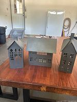 Front view of all three tin candle houses on table