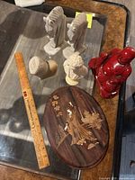 Top view of all figurines and wooden picture, ruler for scale.