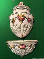 Top view of the whole three-piece Lavabo wall hanging planter set showing floral and fruit relief decoration on ceramic.