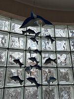 Full view of the hanging mobile showing a large blue whale and multiple smaller blue fish suspended by strings.