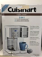 Front of the box showing brand, model, and image of the 2-in-1 coffeemaker with 12-cup carafe and single serve side, as well as key features.