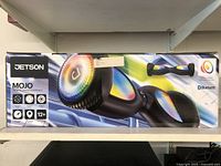 Photo of the front side of the Jetson Mojo hoverboard sealed box showing colored lava-tech rims and Bluetooth logo.