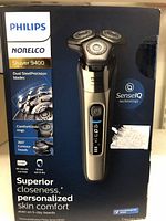 Front of the product box showing Philips Norelco Shaver 9400 with SenseIQ technology, ComfortGlide rings, and wet/dry features.