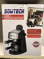Photo of front box showing brand, model CM6811, espresso machine with promotional image of two people and coffee beans, highlighting features: single knob for function, easy control, and 12 month warranty.
