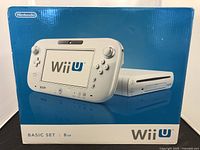 Front view of the Wii U Basic Set box showing the console and GamePad in white color with 8GB storage indication.