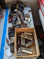 Overview of assorted knives, packaging, sheaths and accessories