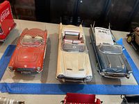 Front and side view of three model cars, showing detail and size relative to each other