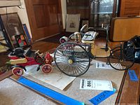 Both green three-wheeled and red four-wheeled models displayed side by side on tabletop