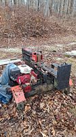 Overall view of horizontal log splitter on ground, red and black steel frame, Honda engine visible
