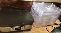 Food dehydrator base with digital controls and stack of eight clear trays