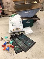 Group shot of wheelbarrow, perlite bag, green case, heat mats, netting and watering stakes