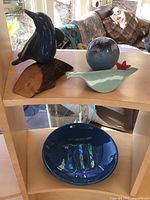 Overall view of two ceramic birds, Lundberg paperweight and fused glass bowl