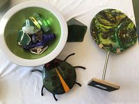 All items arranged: bug, bowl with contents, glass pyramid, glass disc on stand