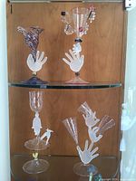 Full view of all four glass sculptures on display shelves