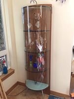 Front full view showing curved glass door, wood sides, glass shelves, metal legs