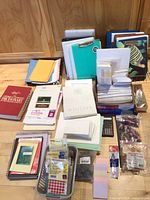 Overview of entire lot showing folders, binders, books, paper, calculator, clips and bands