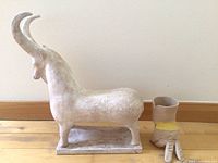 Goat sculpture and ceramic glove side by side