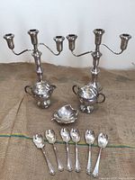 Full lot showing candelabras, creamer, sugar bowl, leaf dish, spoons