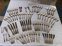 Full layout of 86-piece Milburn Rose sterling flatware