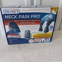 Box front showing Dr Ho Neck Pain Pro with relief areas: headaches, neck, and shoulder pain. Includes branding, product image, and contact info.