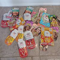 Overview of 28 skincare products including 7th Heaven face masks, serum capsules, and blemish dots spread out on floor.