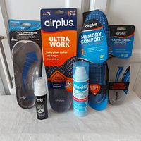 Full lot of Airplus branded insoles, foot odor spray and shoe shine liquid displayed on white background