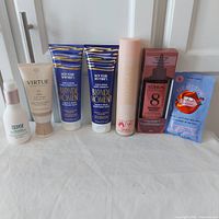 Photo of all seven hair care products arranged in a row showing front labels and packaging colors