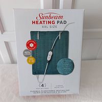 Front packaging showing Sunbeam XXL heating pad with product features and image of heating pad and controller.