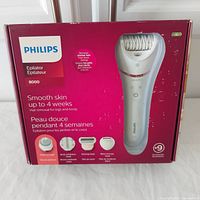 Photo of sealed boxed Philips Series 8000 Epilator showing product image, accessories, and key features