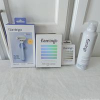 Full view of all items included in the lot: razor handle box, two replacement cartridge packages, and shaving gel can.